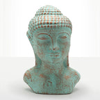A distressed Buddha head bust sculpture with a turquoise and rust-colored patina, set against a plain white background.