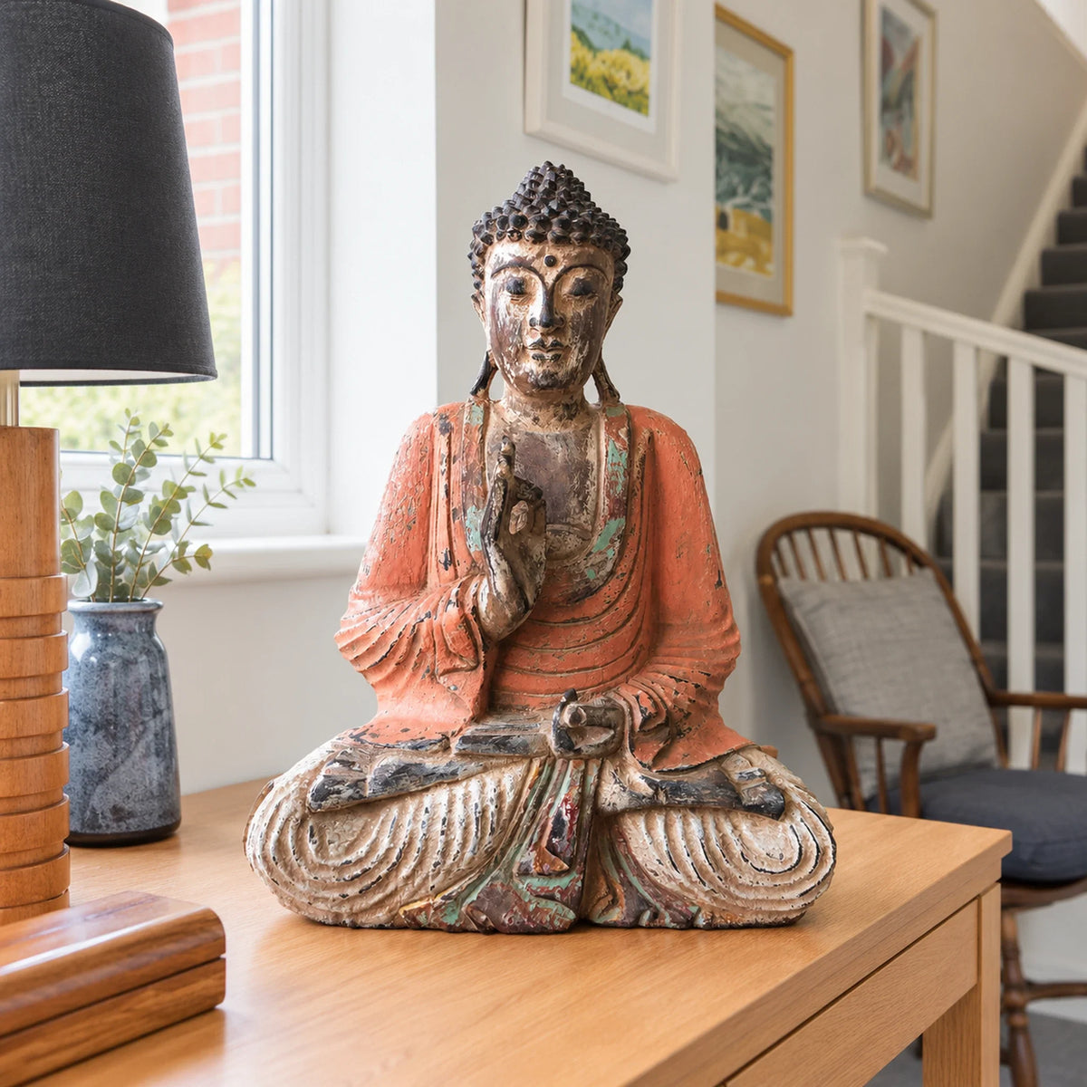 40 cm vintage orange wooden Buddha in a teaching pose on an oak hallway console.