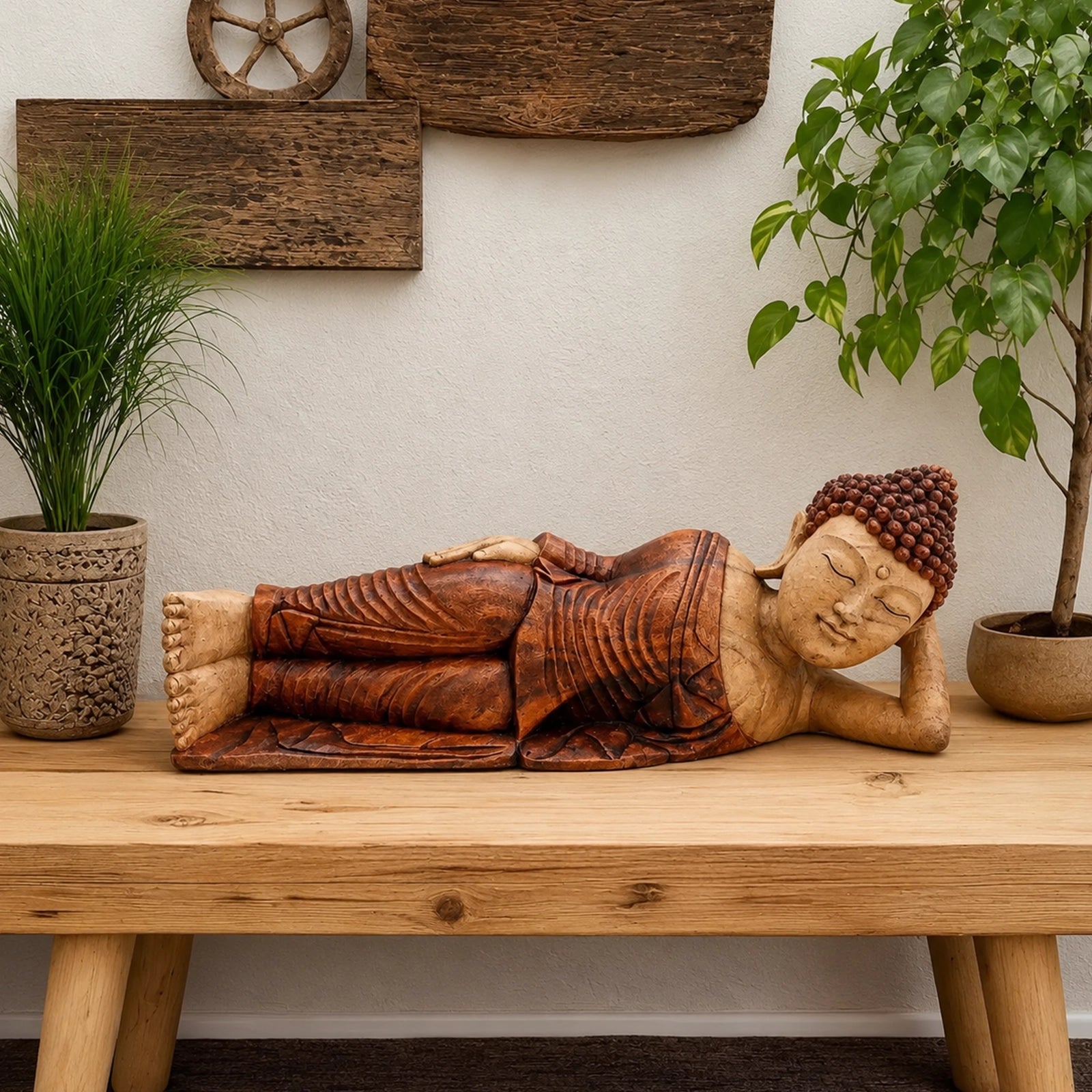 Wooden Sleeping Buddha - 50cm hand carved statue in serene reclining pose, displayed on a wooden table with natural decor including plants and rustic wall art.
