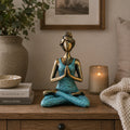 Yoga Lady Figure - Bronze & Turquoise 24cm depicts a serene woman in a seated yoga pose with hands in prayer, featuring a bronze finish and turquoise outfit.