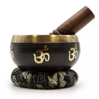 Tibetan singing bowl with wooden handle on a white background