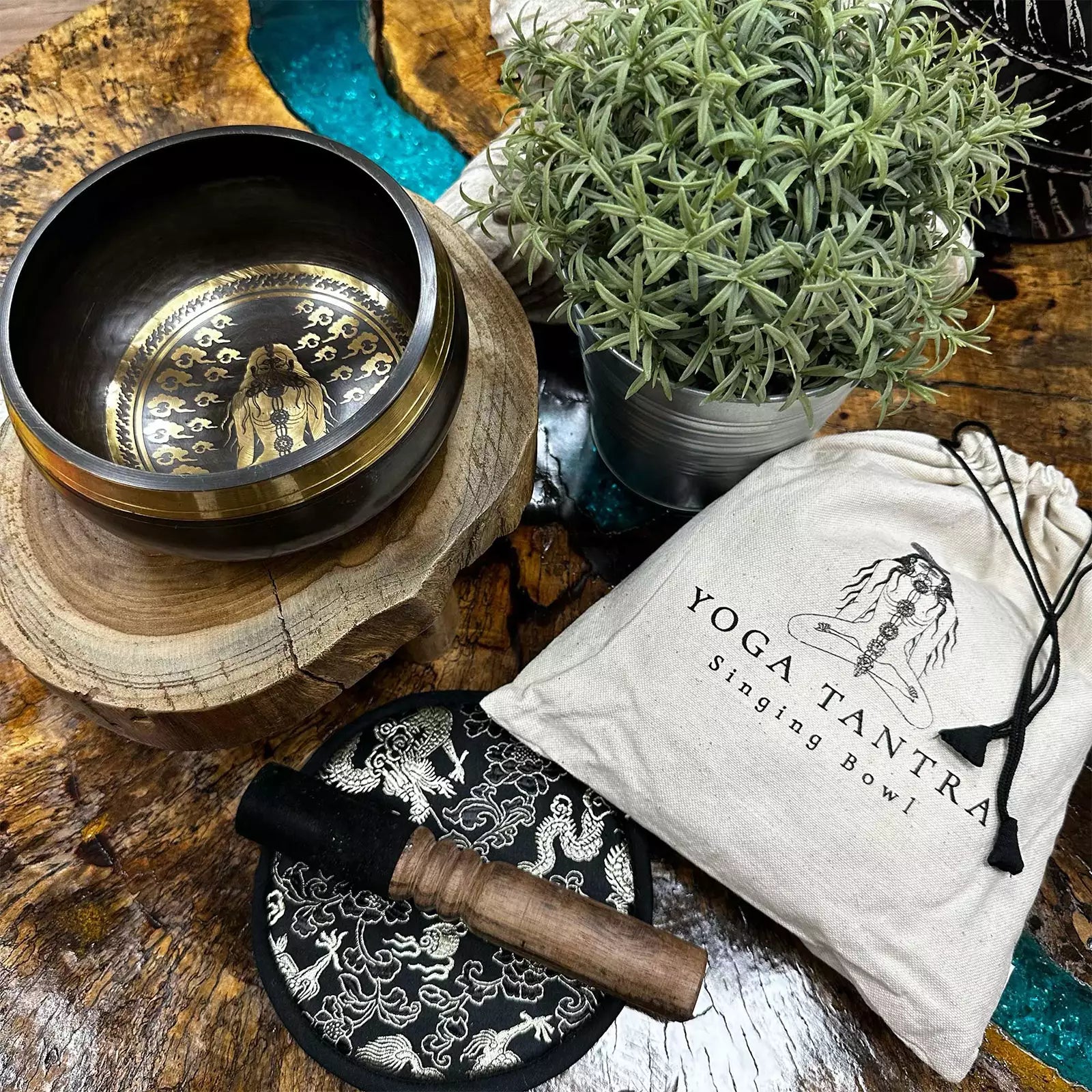 Yoga Tantra singing bowl set with bowl, mallet, and pouch on a wooden surface.