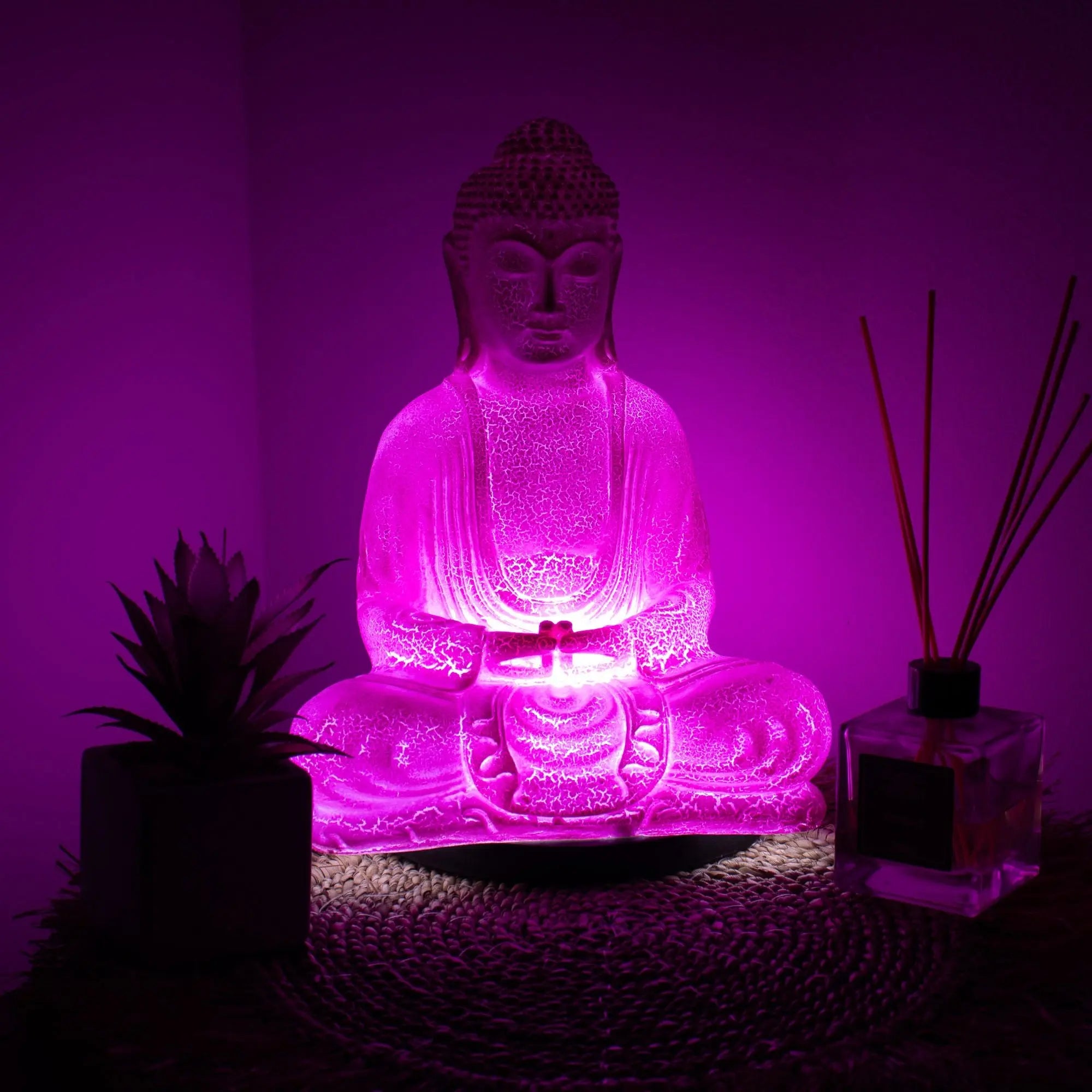 Meditation Buddha Lamp Cherry Crackle - Oval Stand glowing with soft pink light, featuring a hand-carved Buddha statue design ideal for calming home decor and meditation spaces.