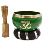 Tree of Life Singing Bowl Set- Green 10.7cm featuring a green bowl with a brass rim and Om symbol, wooden striker, and black cushion with silver accents for meditation and sound healing.
