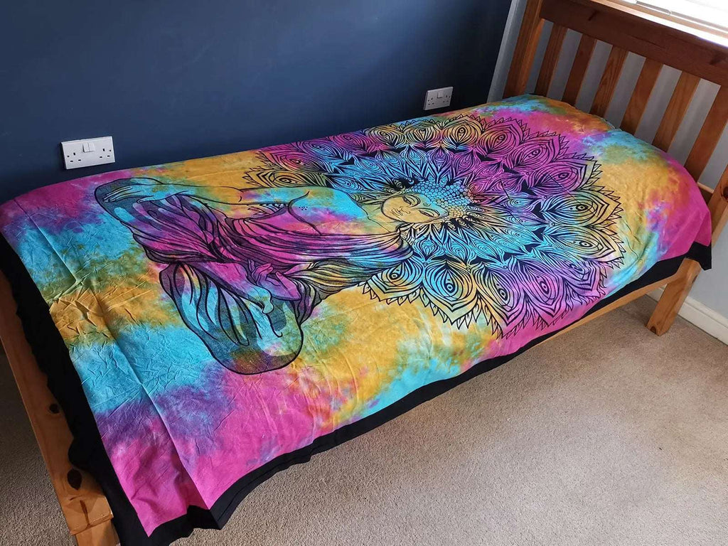 Single Cotton Bedspread + Wall Hanging - Peaceful Buddha featuring a vibrant multicolor tie-dye background with an intricate black outline of a meditating Buddha and lotus petals, displayed on a wooden bed frame.