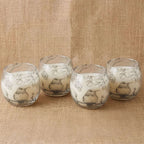 Four Small Glass Jar Candles - Drawn by Flame with delicate black bird and floral sketches on frosted glass, set against a natural linen background.