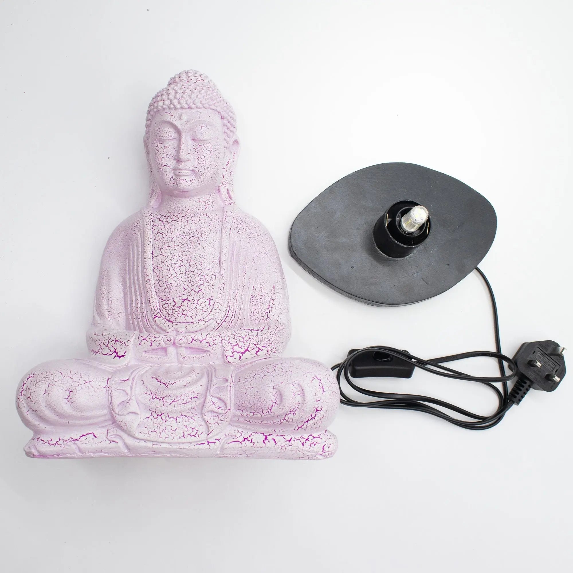 Meditation Buddha Lamp Cherry Crackle - Oval Stand shown disassembled, featuring a pink crackled resin Buddha statue and an oval black lamp base with a light bulb and power cord.
