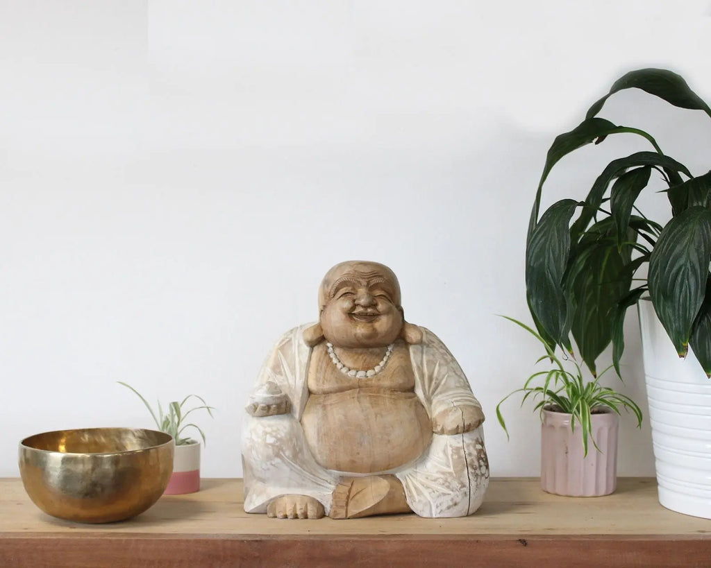 Happy Buddha - Whitewash 30cm hand carved Buddha statue in a whitewashed finish, displayed on a wooden surface with potted plants and a brass bowl, creating serene Buddha decor.