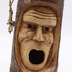 Hand-carved wooden Tree Trunk Face - Bird House - Grumpy Old Man with detailed wrinkles and open mouth for bird entry, natural bark texture, rustic outdoor decor.