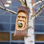 Tree Trunk Face - Bird House - Grumpy Old Man handcrafted from natural wood, featuring a carved grumpy old man’s face with a small bird perched inside, hanging outdoors on a tree branch.