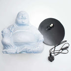 Laughing Buddha Lamp Sky Blue - Round Stand featuring a sky blue Buddha figure with a cracked texture, sitting with a joyful expression beside a black round lamp base and power cord.