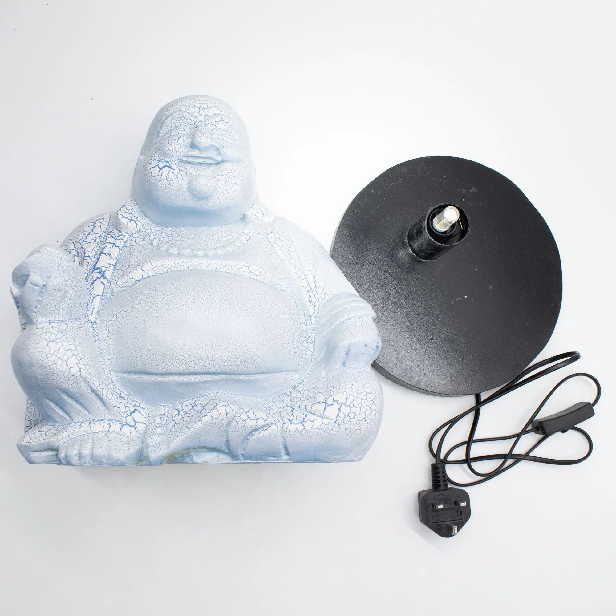 Laughing Buddha Lamp Sky Blue - Round Stand shown disassembled with a sky blue Buddha lamp figure and a separate black round electric stand with power cord and switch.
