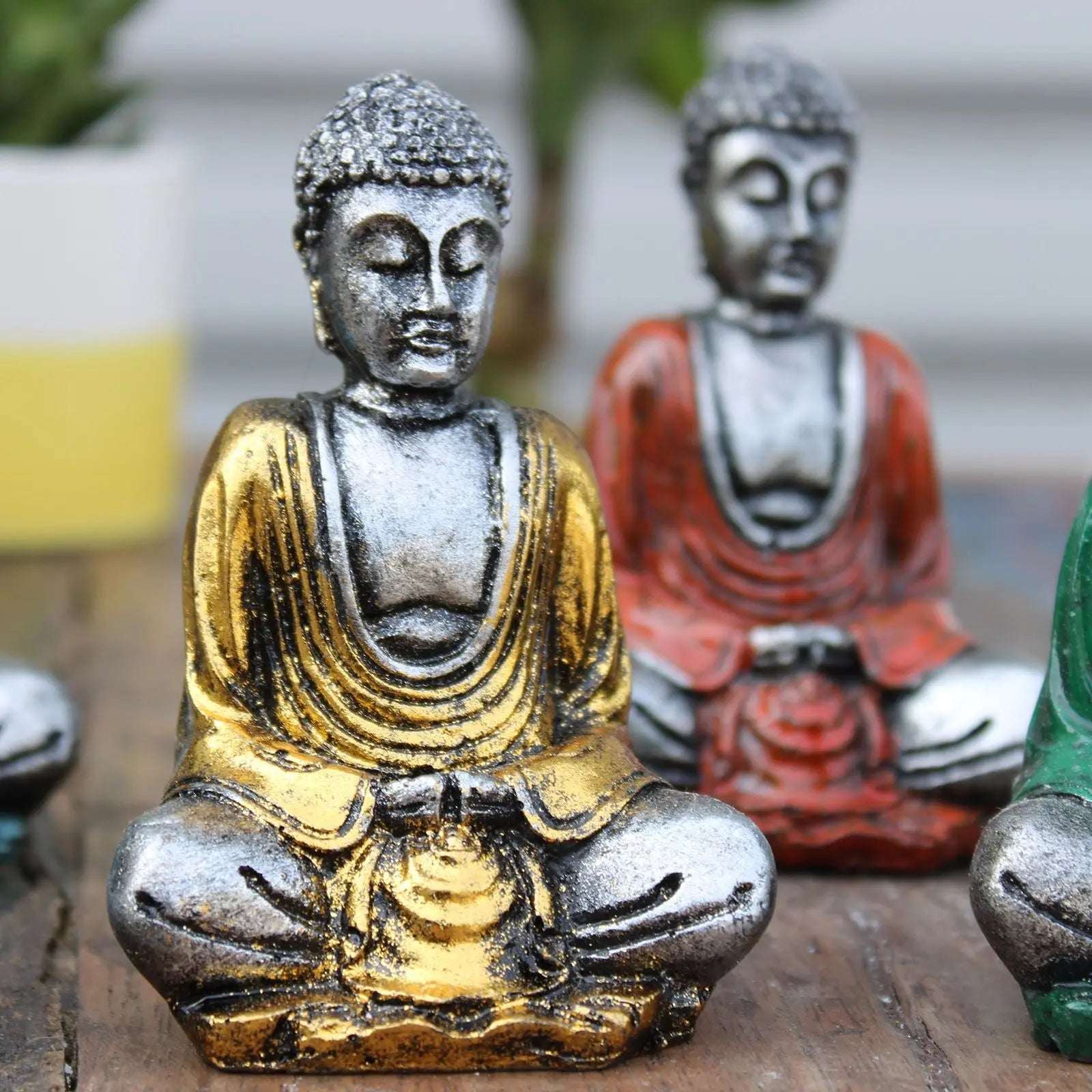 Silver Mini Buddha (Assorted Colours) featuring a hand-painted, silver and gold resin Buddha statue in a meditative pose, ideal for serene tabletop decor and spiritual ambiance.