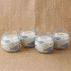 Four Small Glass Jar Candles - Seabreeze featuring blue fish patterns on frosted glass, placed on a textured beige fabric background.