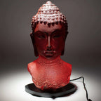 Buddha Bust Lamp Molton Lava - Oval stand featuring a textured red Buddha head sculpture on an oval black base, creating a warm and meditative glow for Buddha decor.
