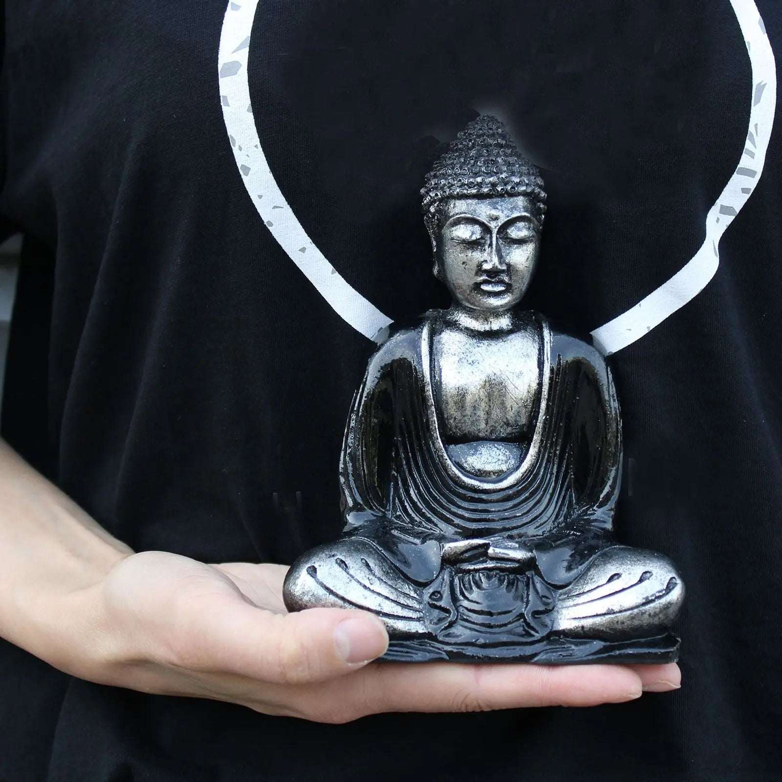 Person holding a Black & Grey Buddha - Medium statue in a seated meditation pose, showcasing intricate details and a serene expression.