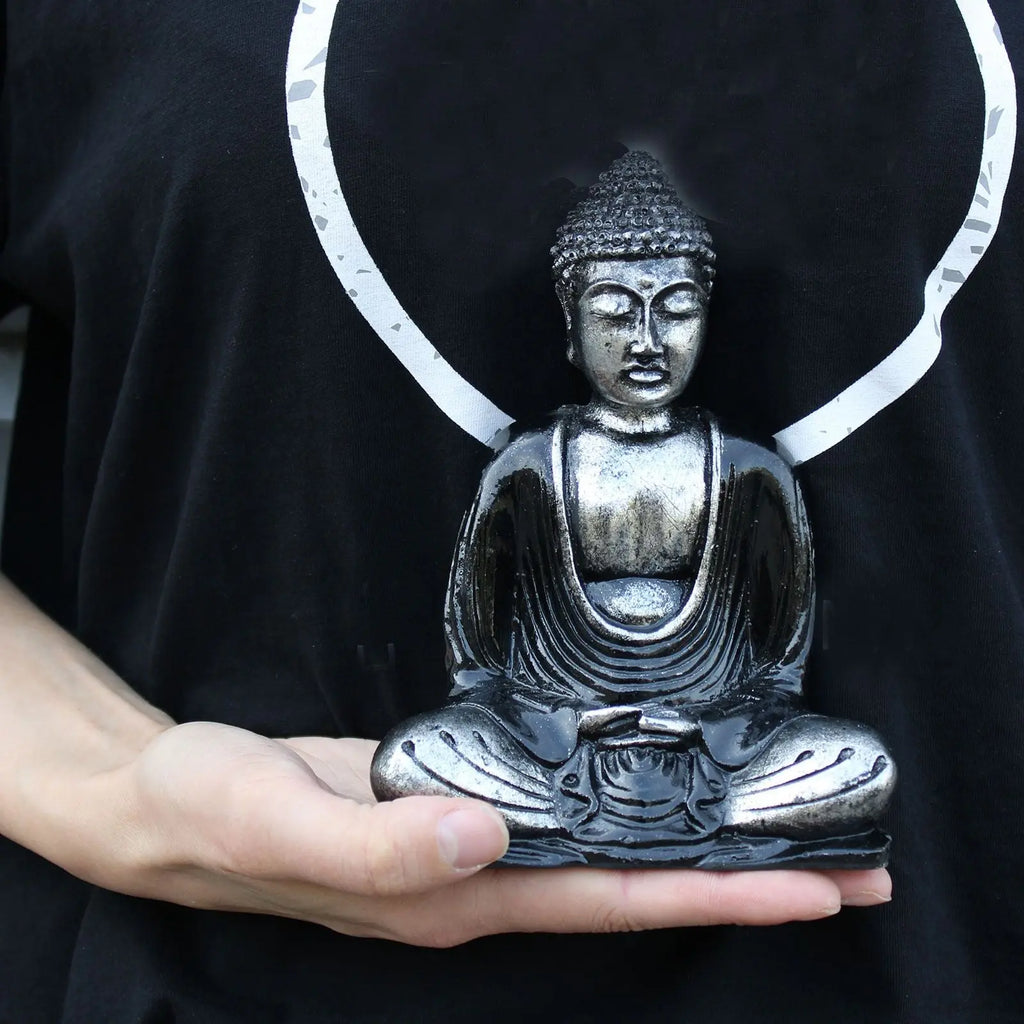 Person holding a Black & Grey Buddha - Medium resin Buddha statue in a meditative seated pose, highlighting intricate hand-carved details and serene expression.