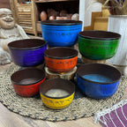 Large Chakra Set of Seven Singing Bowls (19.5-35cm) displayed on a woven mat with vibrant colors and engraved script, surrounded by calming home decor elements.