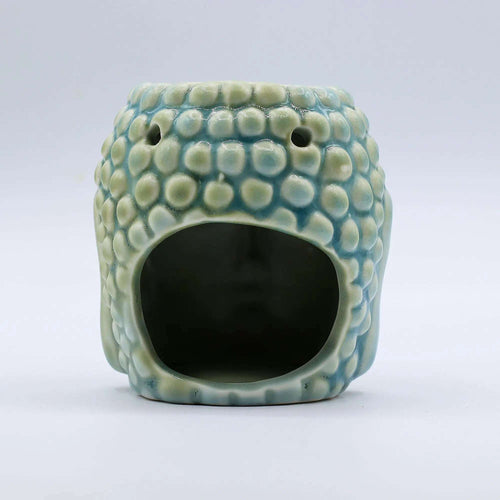 Ceramic Buddha Oil Burner - Blue with textured surface resembling Buddha head, designed for gently warming essential oils and enhancing calming atmosphere.