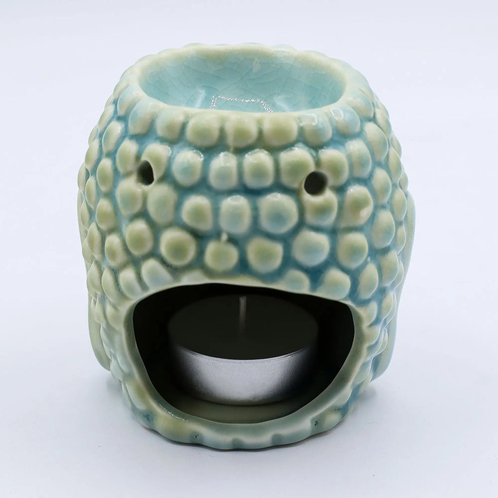 Ceramic Buddha Oil Burner - Blue with textured design, featuring hollow spaces for tealight placement to gently warm essential oils or wax melts, creating a calming ambiance.