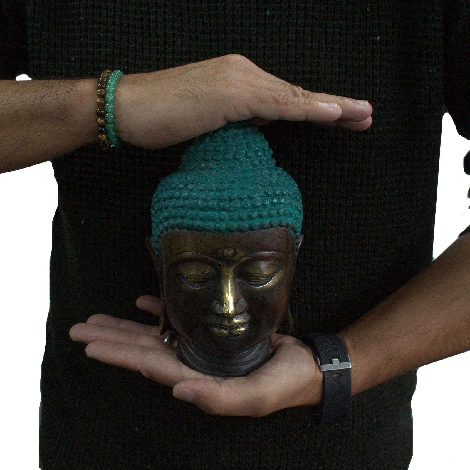 Person holding a Large Classic Brass Buddha Head with a serene expression, featuring detailed craftsmanship and a turquoise patina on the hair.