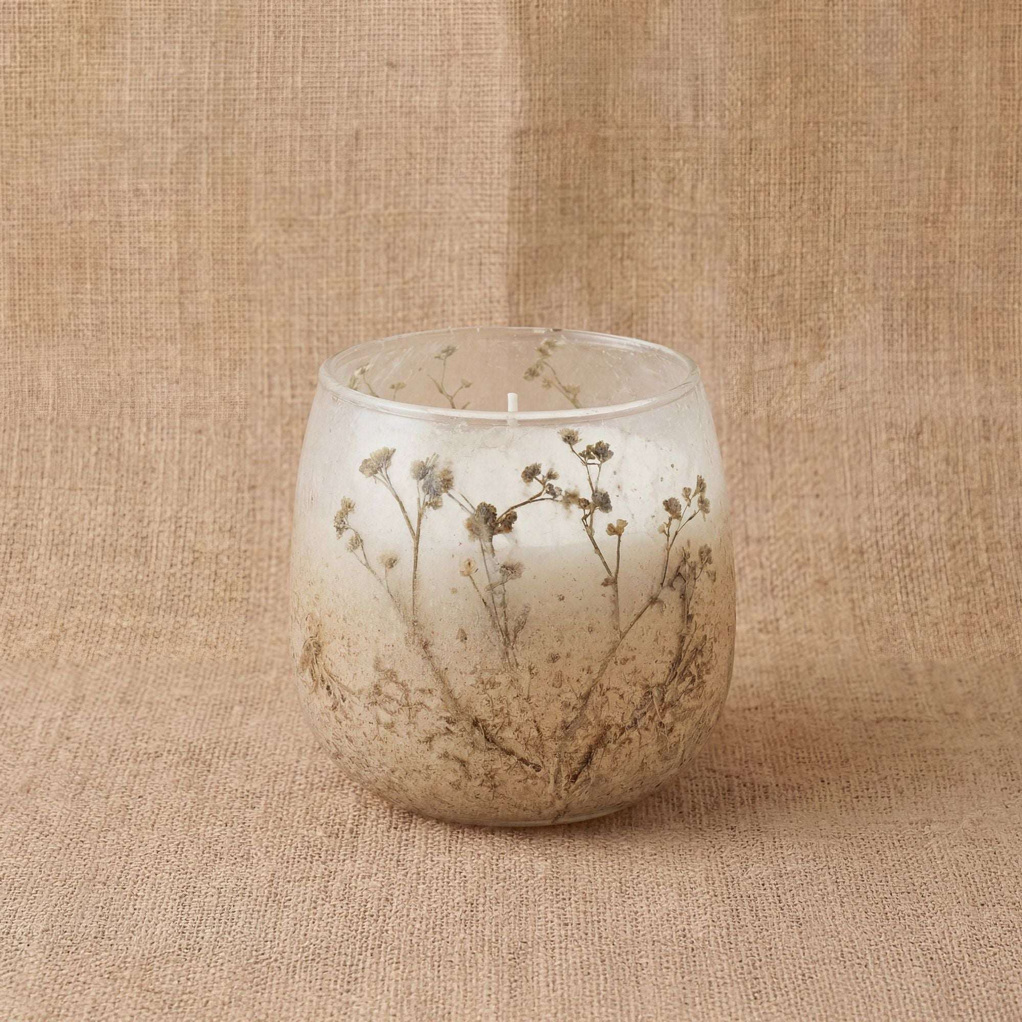 Small Glass Jar Candles - Wildlight Woods featuring a translucent glass jar with delicate embedded wildflower designs against a natural textured fabric background.