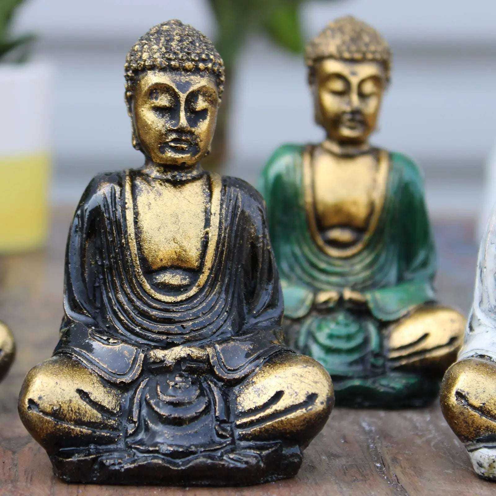 Gold Mini Buddha (Assorted Colours) featuring a hand-carved Buddha statue in black and gold finish with serene facial expression and detailed robes, ideal for Buddha decor.