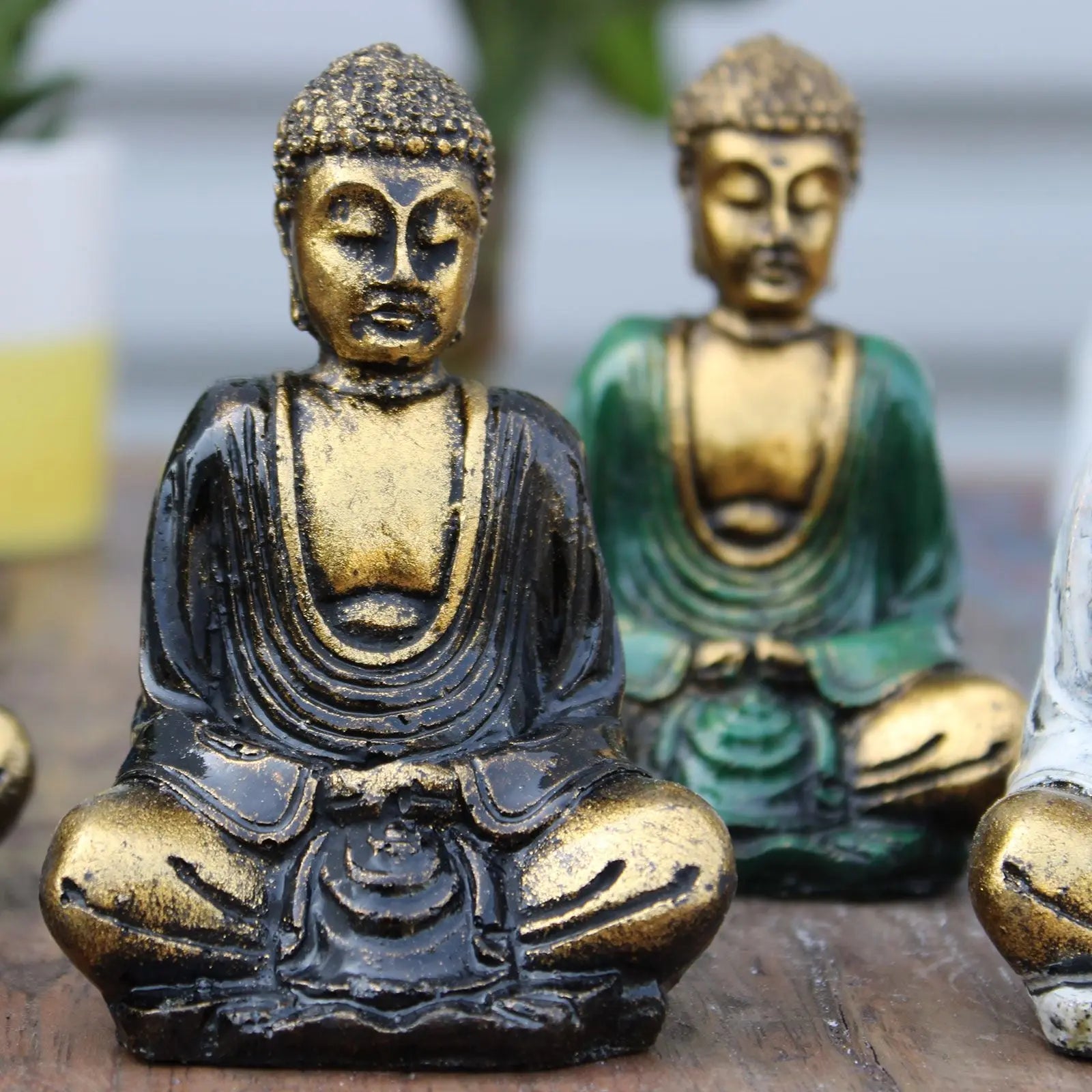 Close-up of Gold Mini Buddha (Assorted Colours) statues with detailed robes and serene expressions, suitable for Buddha decor and tabletop display.