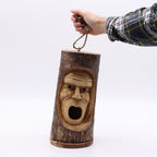 Hand holding a carved wooden bird house shaped like a grumpy old man's face with an open mouth, crafted from a tree trunk, titled Tree Trunk Face - Bird House - Grumpy Old Man.
