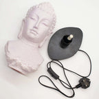 Buddha Bust Lamp Cherry Crackle - Oval stand with a cracked pink Buddha head sculpture and separate black oval lamp base with power cord and switch.
