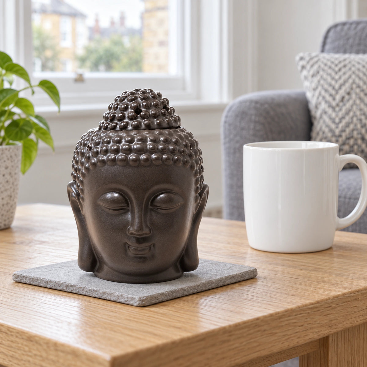 Buddha Head Oil Burner - Dark Brown on a stone mat in a British sitting room