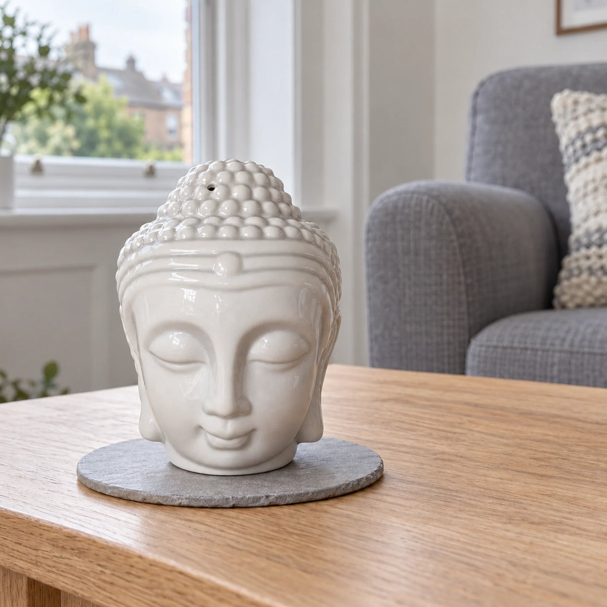 Buddha Head Oil Burner - White on a stone mat in a British sitting room