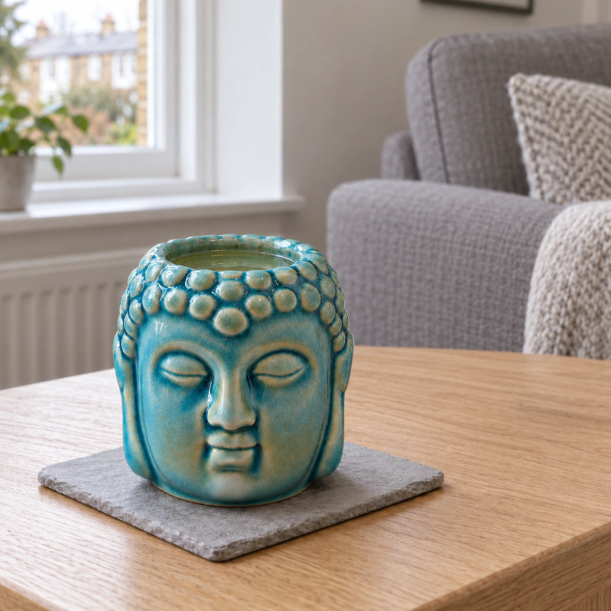 Buddha Oil Burner - Blue on a stone mat in a British sitting room