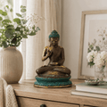 Elegant Large Sitting Solid Brass Buddha statue with a patina finish, displayed on a wooden surface with decorative flowers and books, enhancing peaceful home decor.