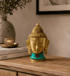 Brass Buddha Figure - Lrg Head - 11.5 cm with intricate detailing and turquoise inlay, displayed on a wooden surface with a calm, minimalist background.