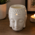 Buddah Head Oil Burner - White made of smooth ceramic with a serene Buddha face design, ideal for creating a peaceful ambiance with warm candlelight.
