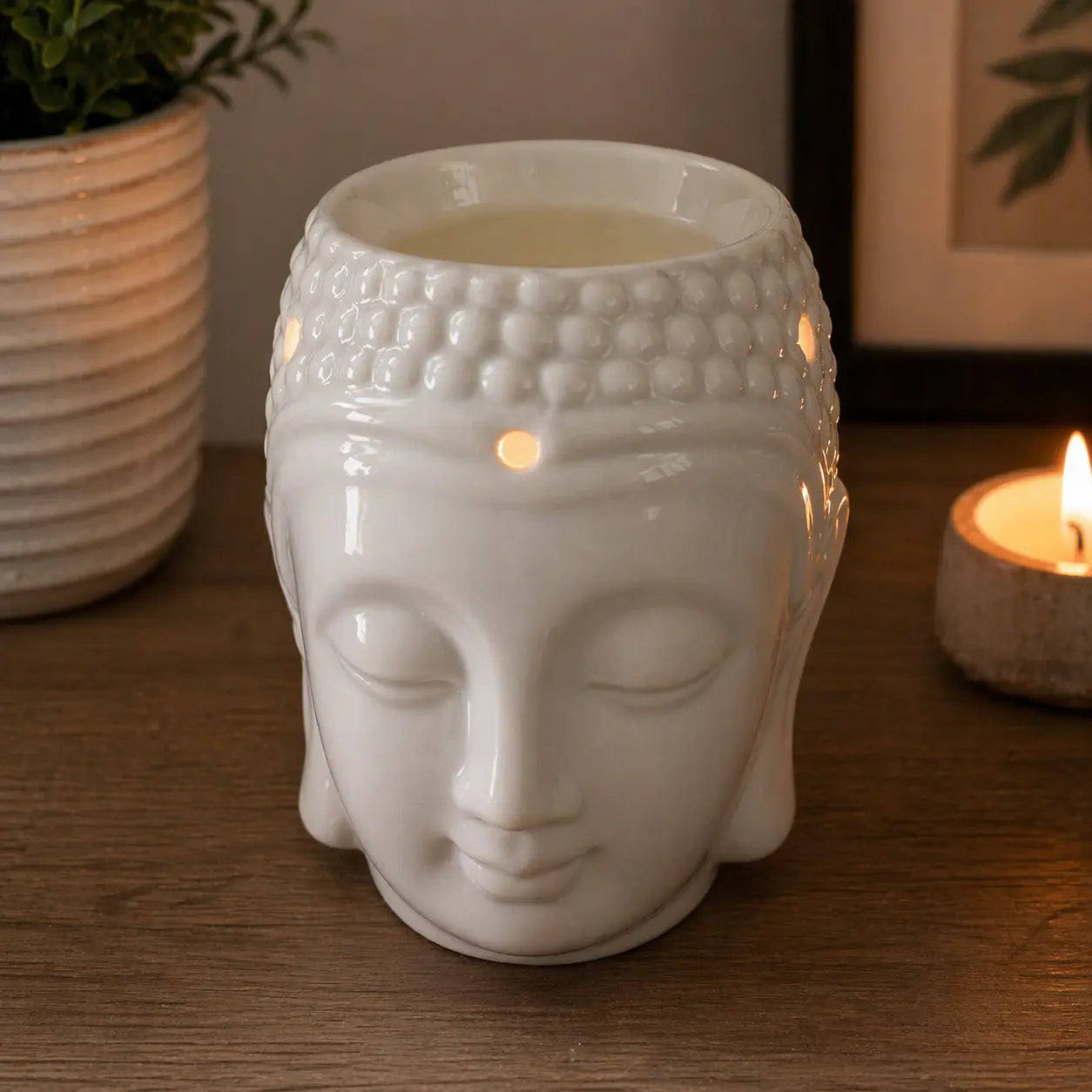 Buddah Head Oil Burner - White made of smooth ceramic with a serene Buddha face design, ideal for creating a peaceful ambiance with warm candlelight.