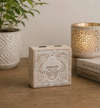 Small Square Box 10x10x4.2cm - Buddha Face Whitewash with an intricate Buddha head design, placed on a wooden surface with decorative candle holder and plant in the background.