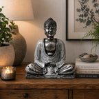 White & Grey Buddha - Medium statue in a serene seated meditation pose displayed on a wooden surface with soft ambient lighting and natural decor around it.