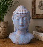Tranquility Buddha Head - Blue Copper with a serene expression and textured blue copper finish displayed on a wooden surface with decorative home accents in the background.