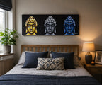 Buddha Painting - Three Heads Black displayed above a bed, featuring three Buddha heads in gold, silver, and blue tones, enhancing bedroom decor with a serene and artistic touch.