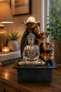 Tabletop Water Feature - 35cm - Silver Buddha Cascade & Crystal Ball showing a serene resin Buddha statue with cascading water and a glowing crystal ball in a cozy interior setting on a wooden surface.