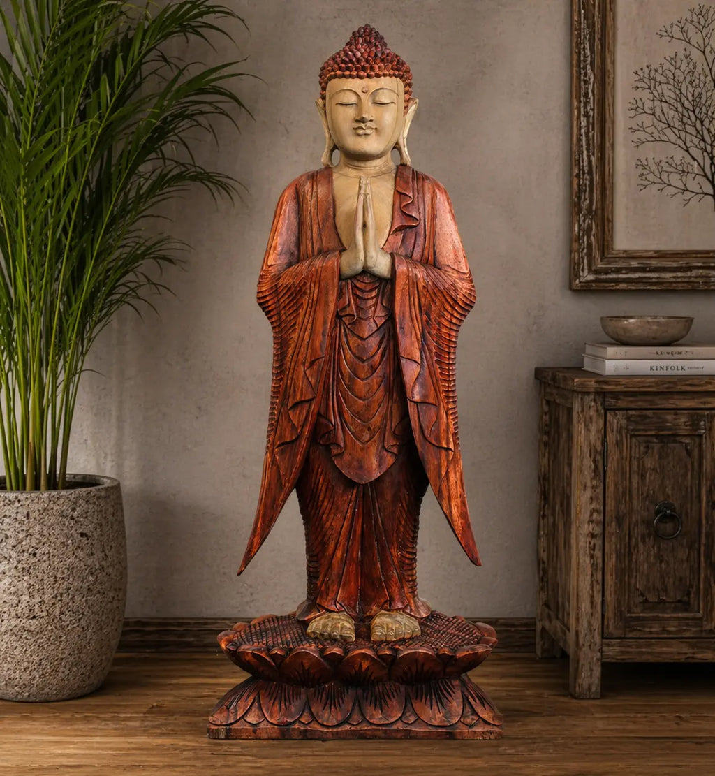 Buddha Statue Standing - 1m Welcome carved from wood with rich reddish-brown robes, hands in prayer position, standing on a detailed lotus base, displayed in a serene indoor setting.