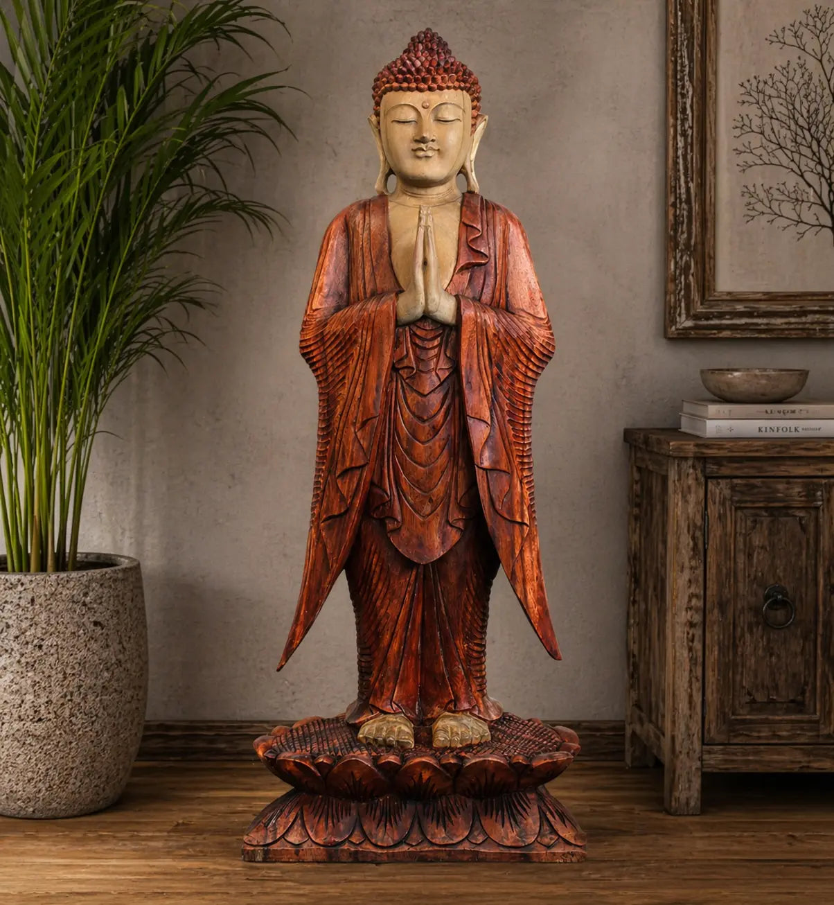 Buddha Statue Standing - 1m Welcome carved from wood with rich reddish-brown robes, hands in prayer position, standing on a detailed lotus base, displayed in a serene indoor setting.