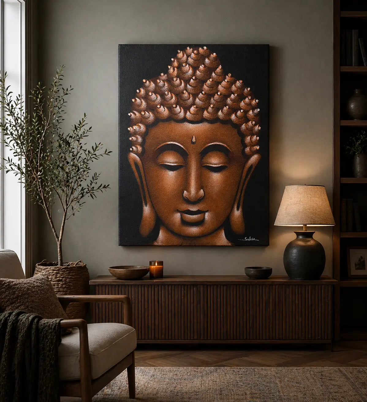 Buddha Painting - Copper Sand Finish hanging on a living room wall above a wooden console with a lamp, small bowls, and a candle, surrounded by cozy furniture and decor.