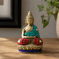 Brass Buddha Figure - Hands Up - 7.5 cm featuring intricate detailing with turquoise and red mosaic accents, seated in a meditative pose on a decorative base.