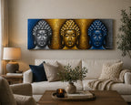 Buddha Painting - Three Heads Gold Detail featuring three stylized Buddha heads in silver, gold, and blue tones, displayed above a modern living room sofa.