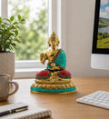 Brass Buddha Figure - Blessing - 15cm sitting on a wooden desk, adorned with turquoise and red detailing, bringing a serene and spiritual touch to a modern workspace.