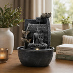 Tabletop Water Feature - 19x19x28cm - Buddha, Lotus Flower Cascading Potsx with hand carved Buddha statue sitting peacefully inside a textured bowl with flowing water and lotus flower design.