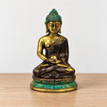 Med Meditation Sitting Brass Buddha Figure, centred on a bare oak surface against a white wall.
